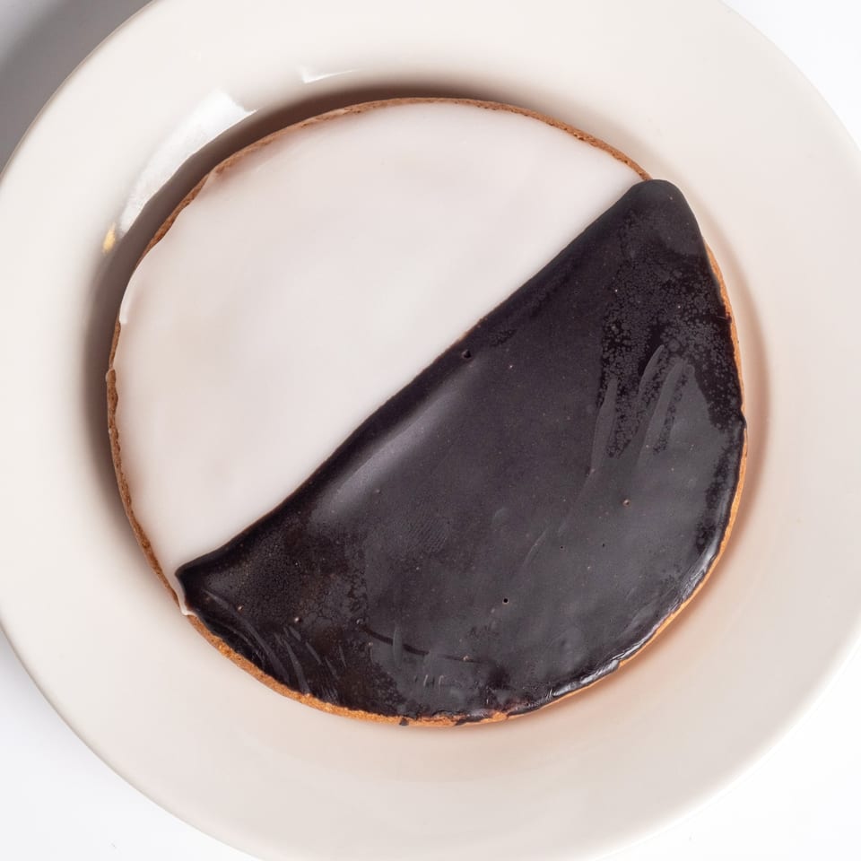 A classic black and white cookie from Sunny Side Diner, half vanilla and half chocolate frosted.
